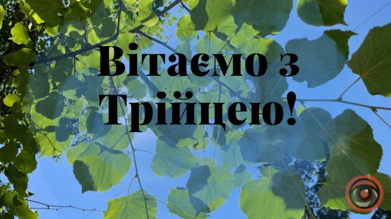 Зелені листя на синьому небі та привітання зі святом.