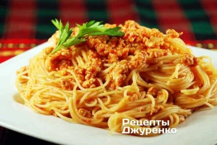 Спагеті з м'ясним соусом на білій тарілці